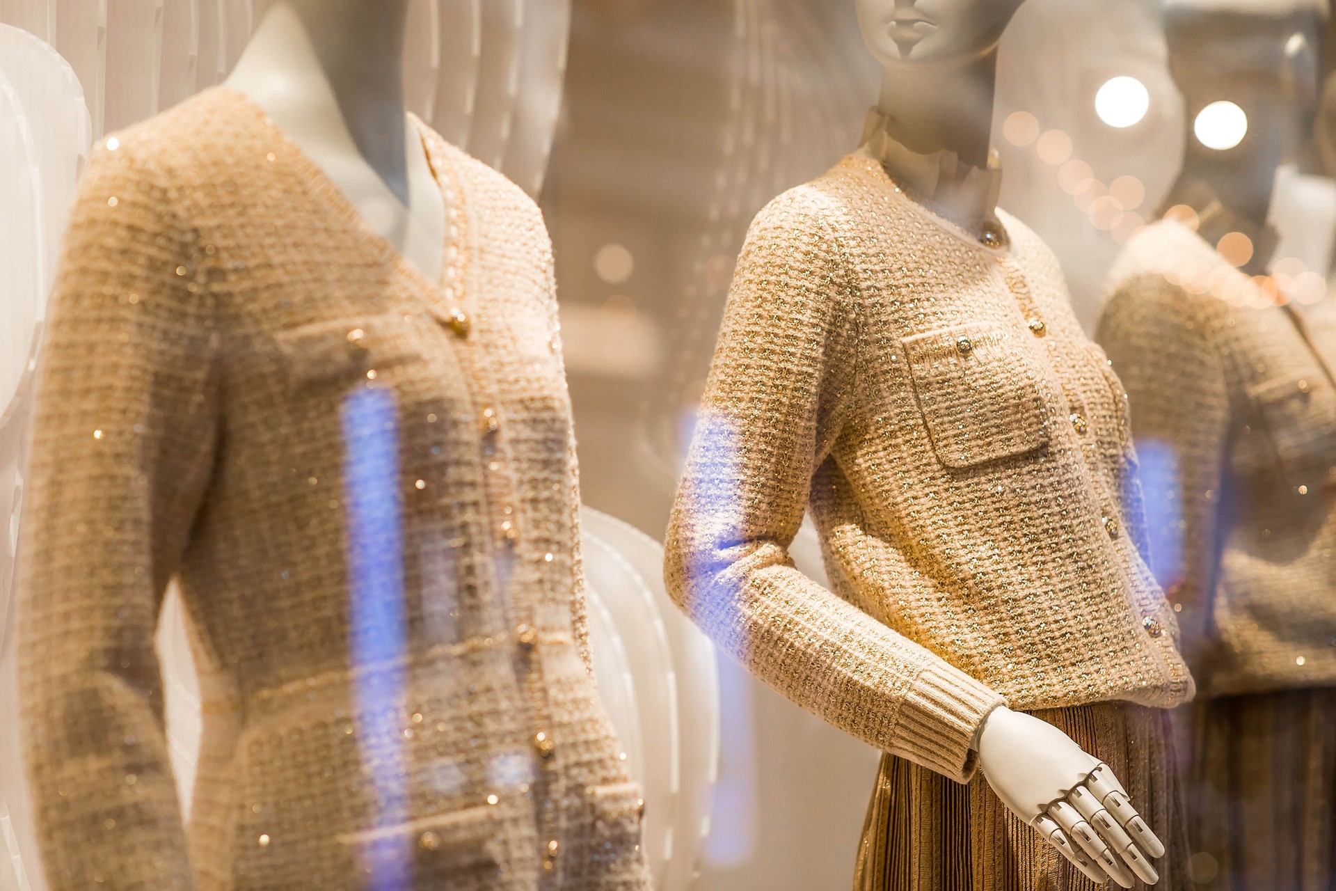 An elegant showcase of an expensive luxury store with stylish mannequins in clothes and evening lighting. The concept of shopping and sales.